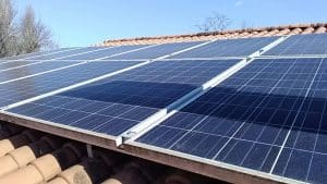 Panneaux solaires photovoltaïques sur toit en tuiles Panneaux solaires photovoltaïques installés sur un toit en tuiles sous un ciel bleu pour une énergie renouvelable.