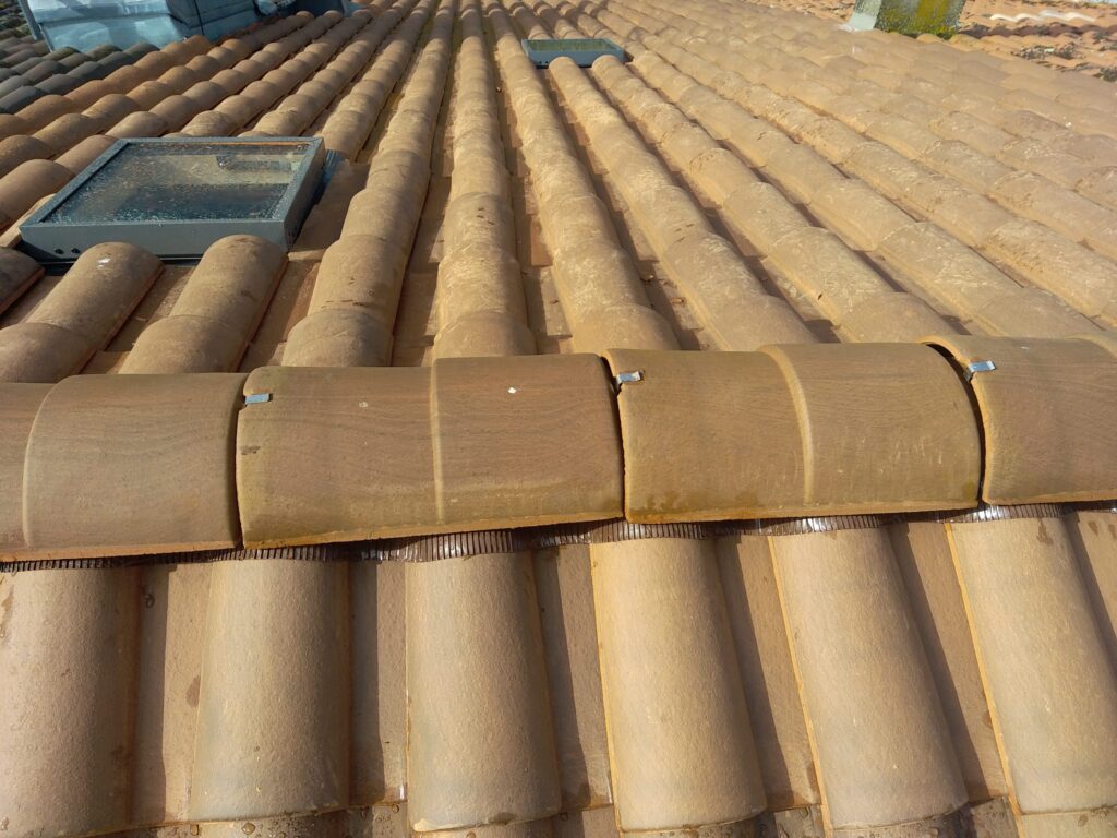 Toiture en Tuiles Canal avec Fenêtres de Toit et Velux Toit en tuiles canal terre cuite avec fenêtres de toit et faîtage fixé par clips métalliques.