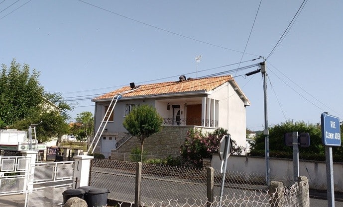 Ouvrier réparant une toiture en tuiles, échelle déployée, Rue Clément Ader.